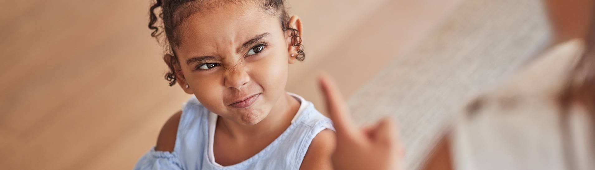 Ein Kind schaut zu einem erhobenen Finger. Wie wir fremde Kinder maßregeln können, verrät uns eine Familienexpertin (Foto: Adobe Stock,  A.S./peopleimages.com)